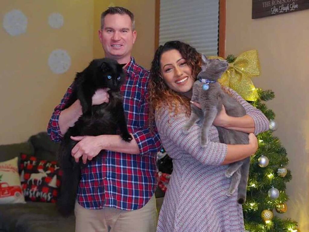 2 people holding 2 cats